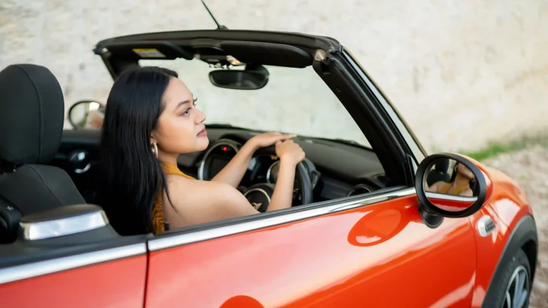 Woman driving an orange MINI Cooper convertible in Bali